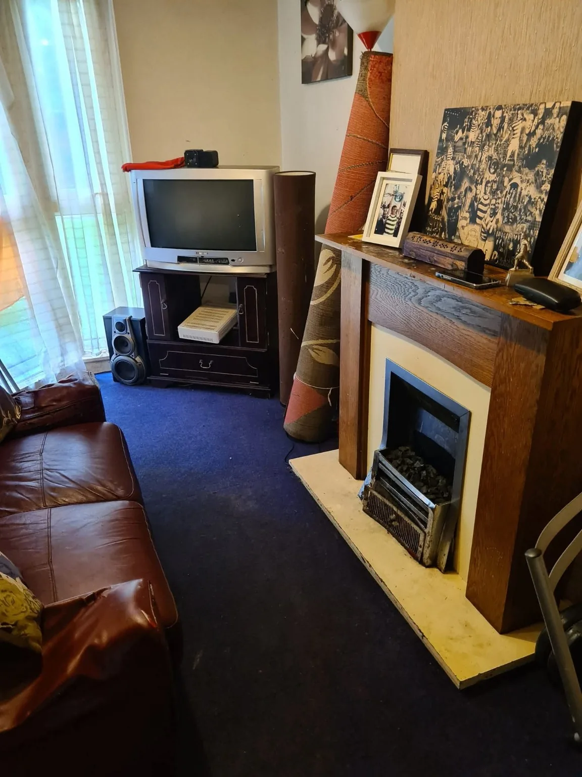 The same living room with floor space cleared around the television and fireplace