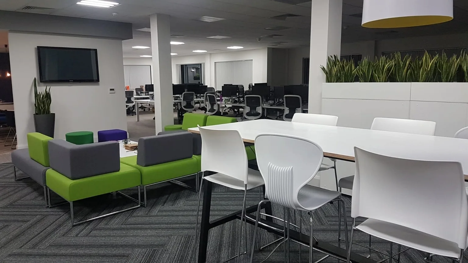 Clean office with shared seating, a high table and desk areas
